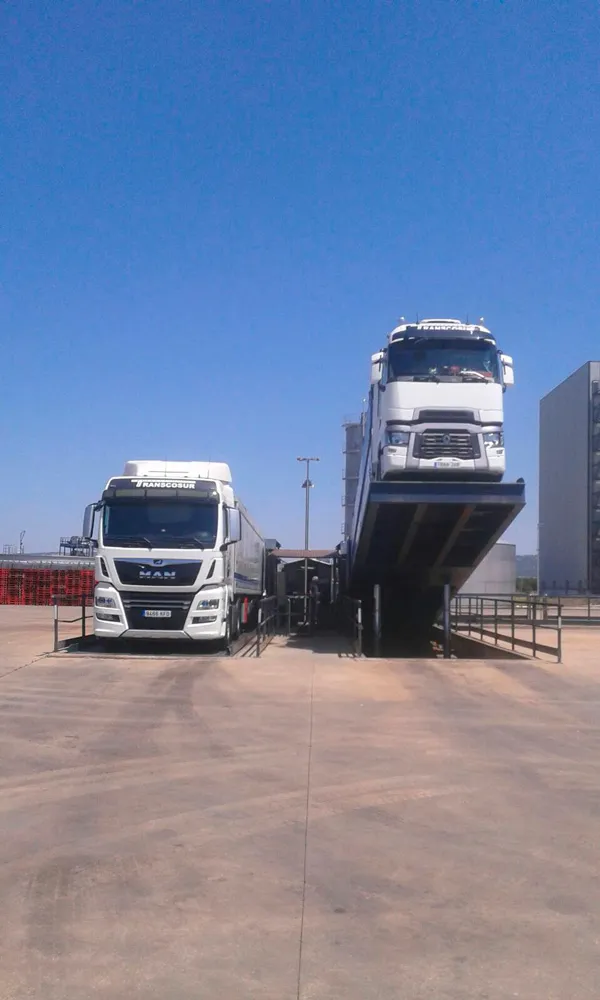 Camión de Transcosur subiendo una rampa de carga, visto de frente